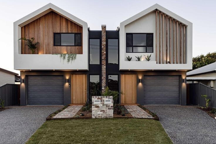 A modern style home with two garages and a driveway.