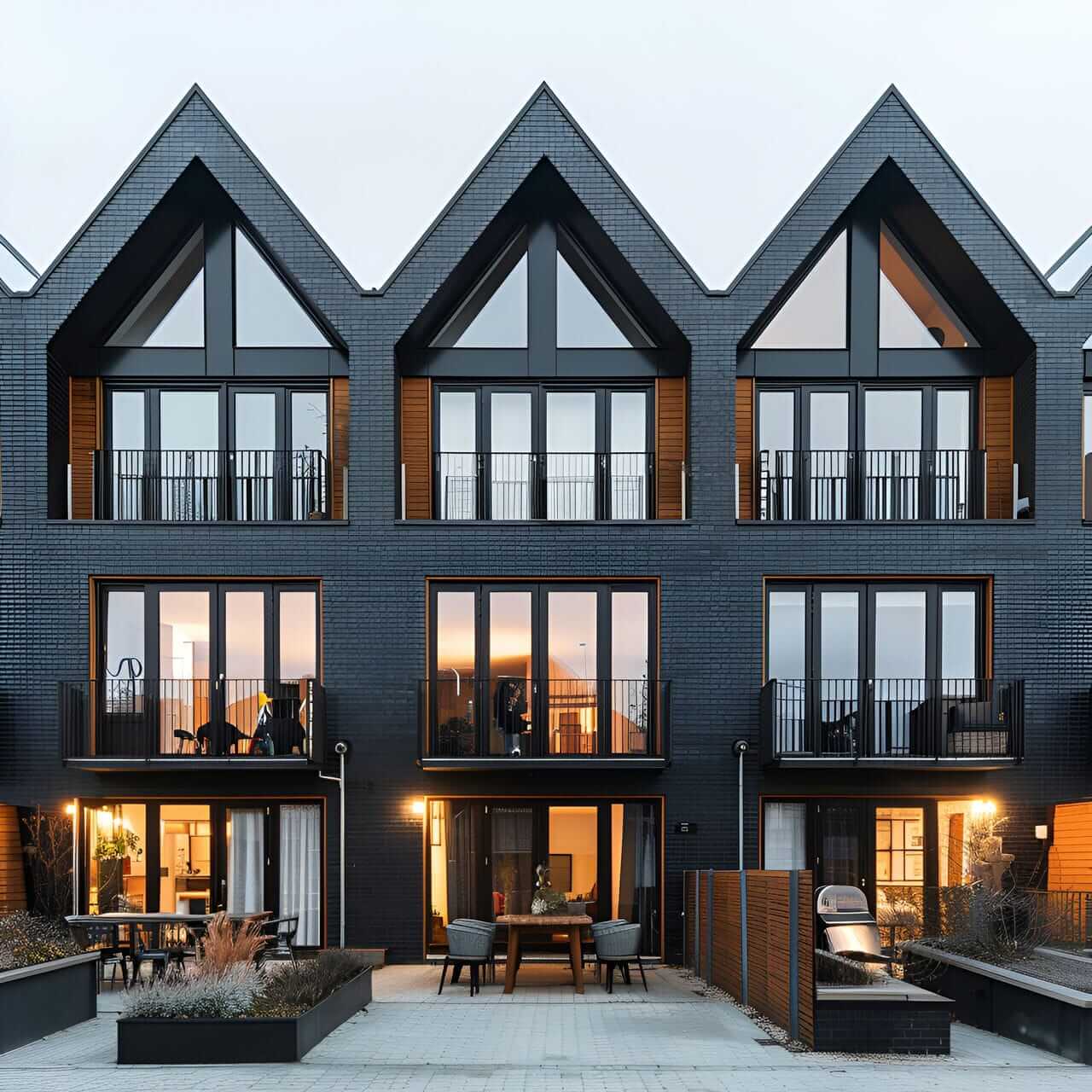 A group of three black houses with windows.