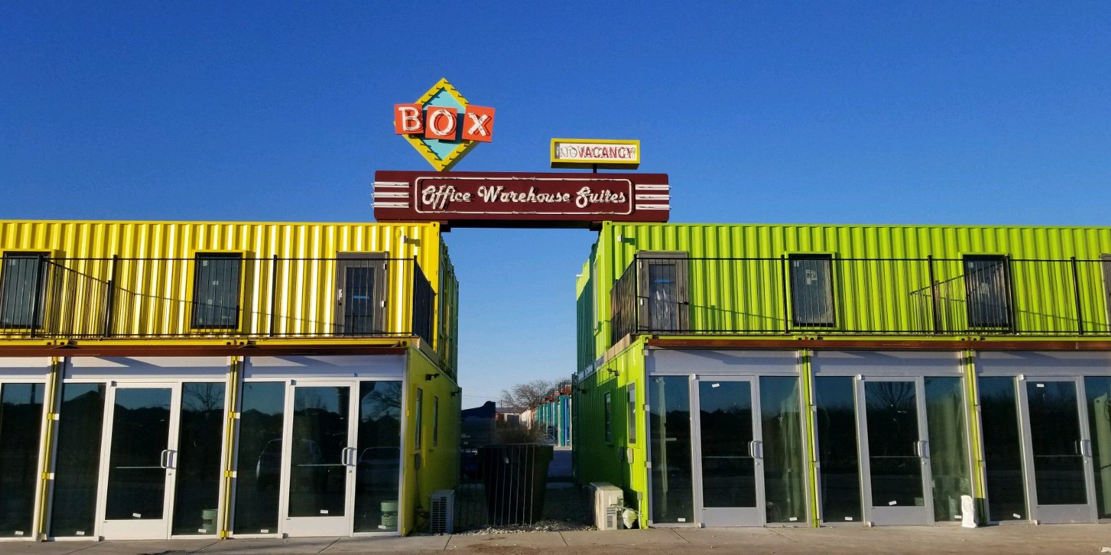 A building that has two windows and a sign on top of it.