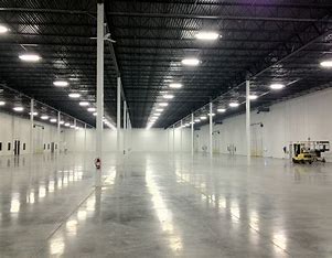 A large warehouse with many lights and people