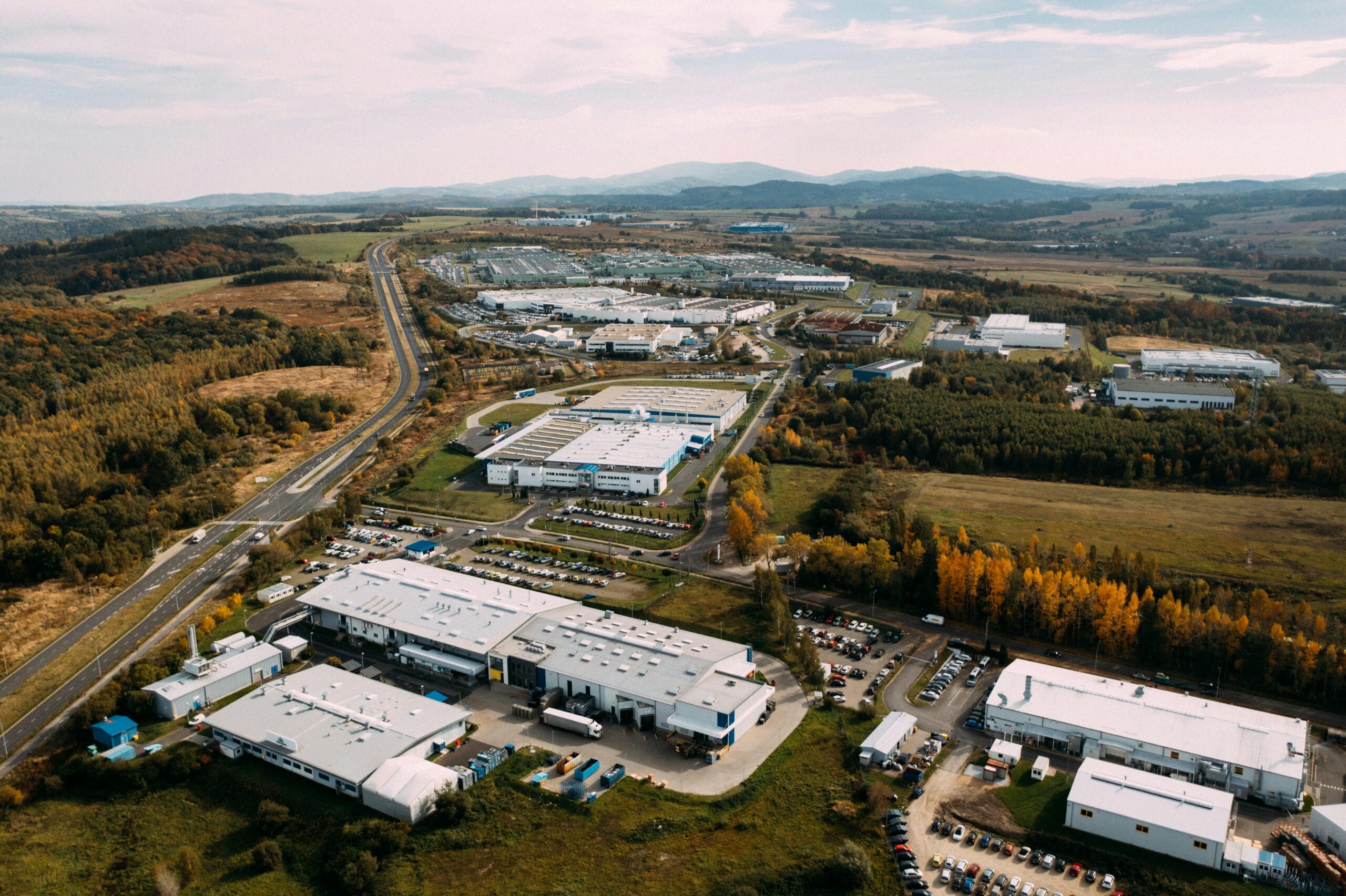 A large industrial area with many buildings and lots of trees.