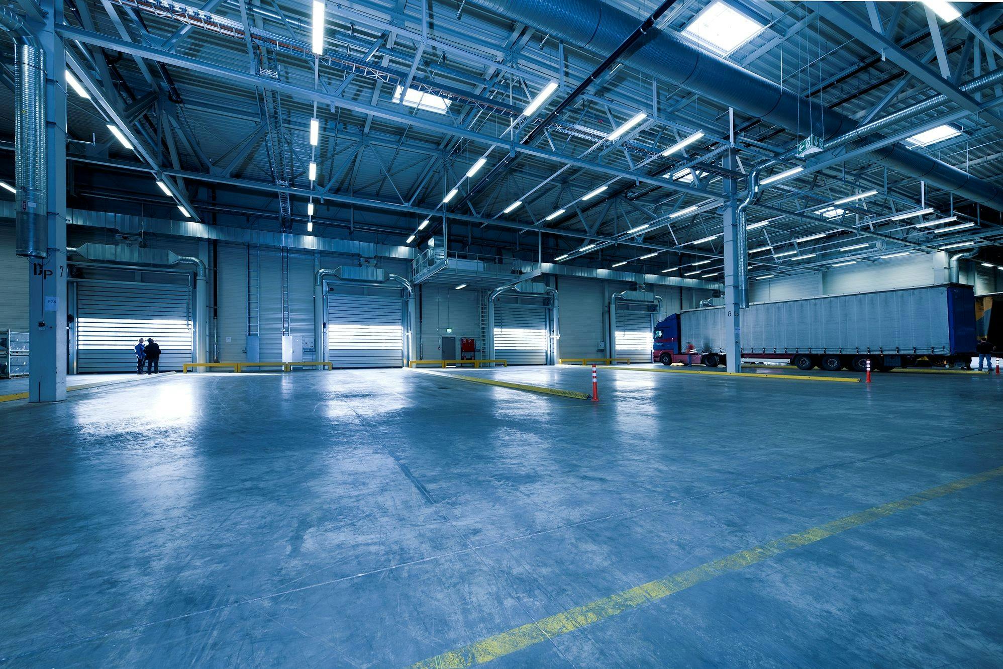 A warehouse with many windows and lots of lights.