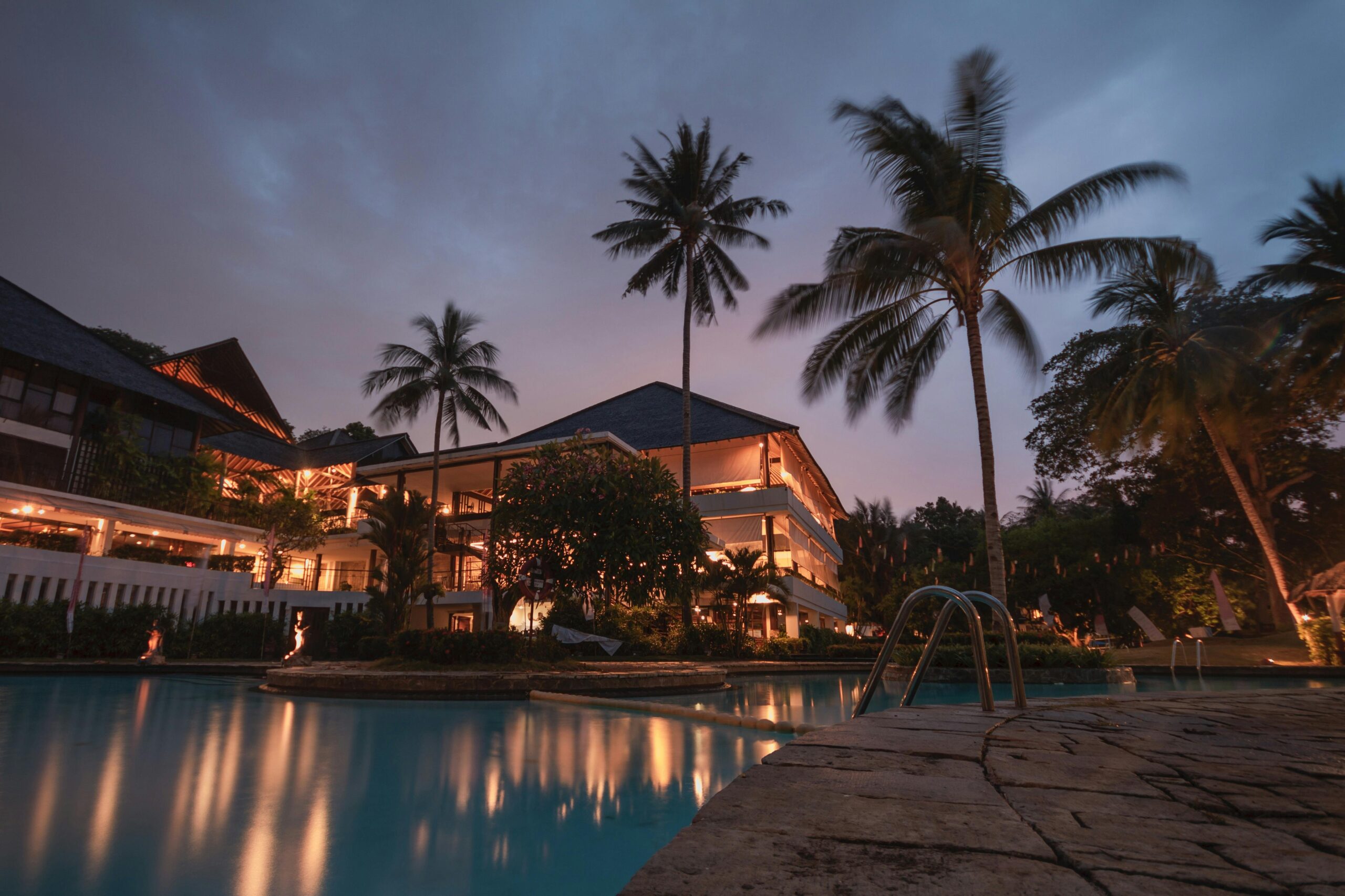 A pool with palm trees in the background